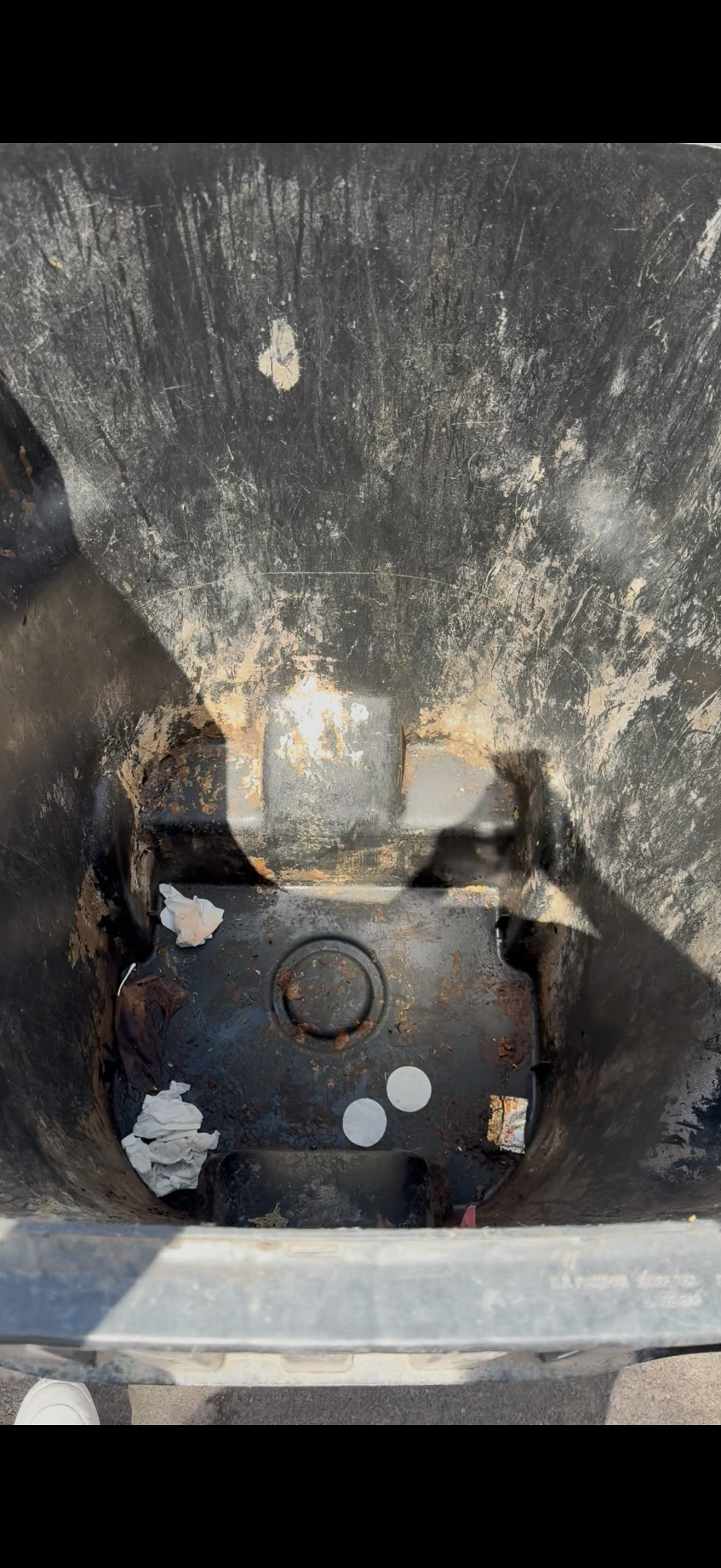 Dirty black trash can — before